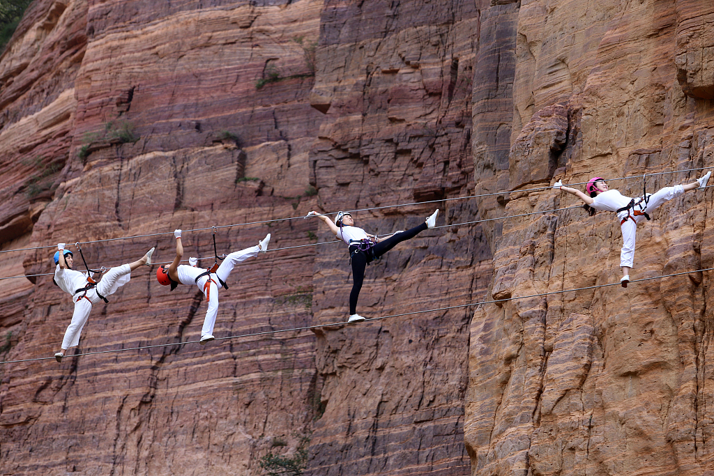 A photo shows sports enthusiasts practicing yoga on high-altitude steel wires on Qingyao Mountain, Luoyang City, Henan Province. /CFP