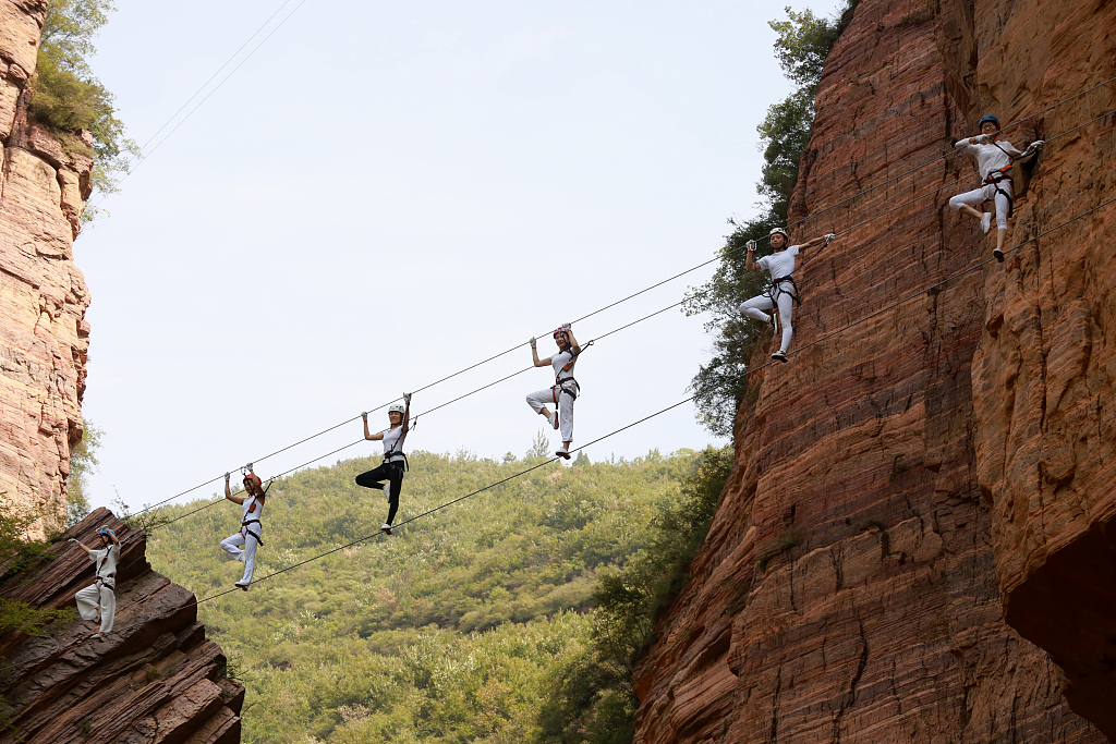 A photo shows sports enthusiasts practicing yoga on high-altitude steel wires on Qingyao Mountain, Luoyang City, Henan Province. /CFP