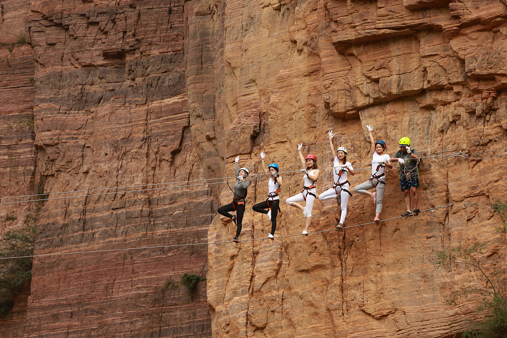 A photo shows sports enthusiasts practicing yoga on high-altitude steel wires on Qingyao Mountain, Luoyang City, Henan Province. /CFP