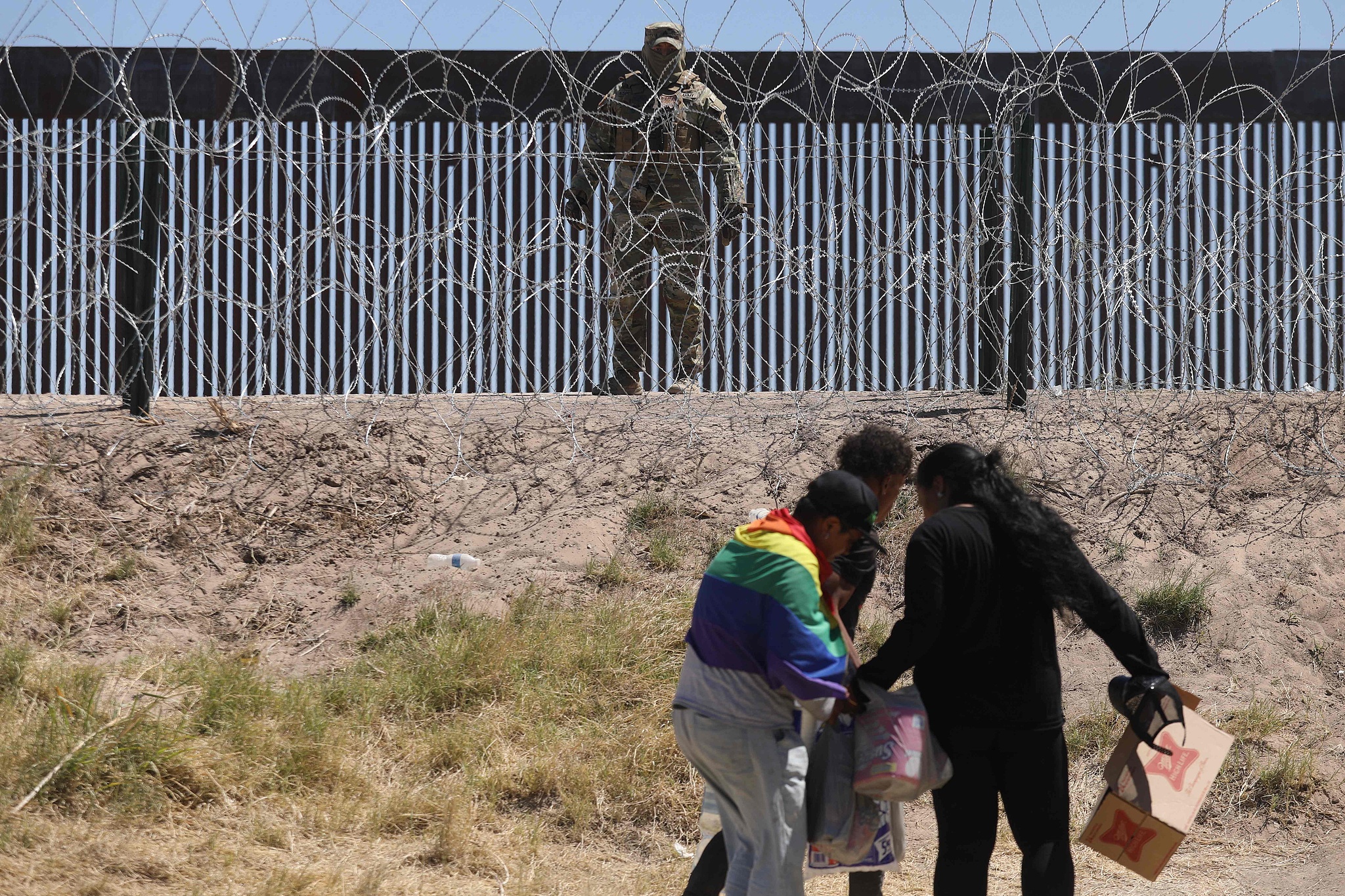 Migrant people carrying food and goods cross the banks of the Rio Grande to be processed by the Border Patrol El Paso Sector, Texas, after crossing from Ciudad Juarez, Mexico, May 8, 2023. /CFP