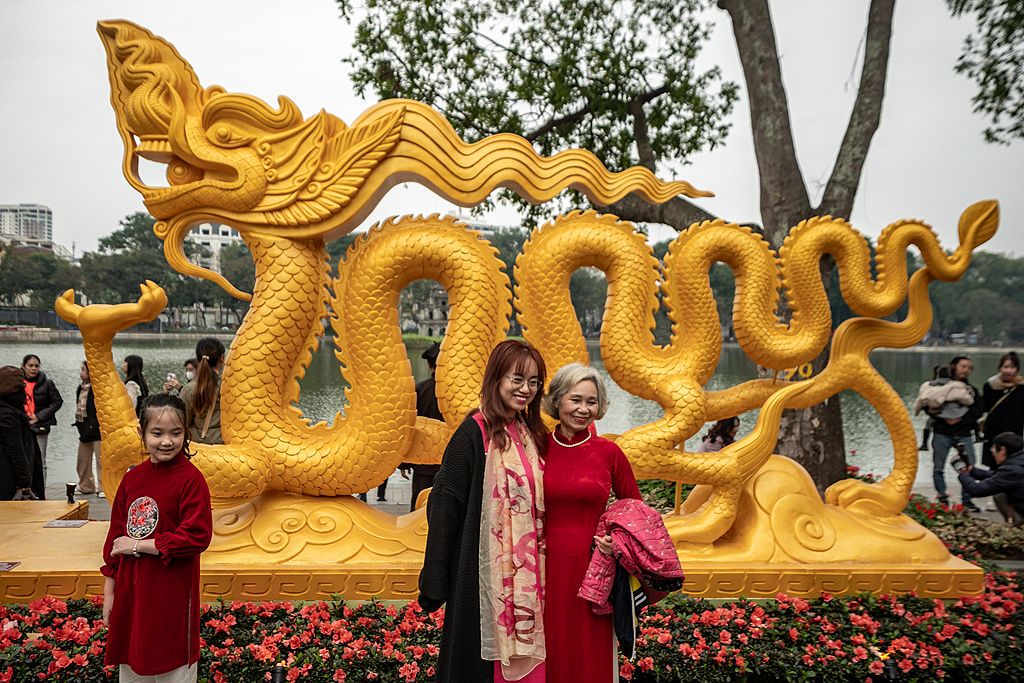 File photo of people taking pictures with golden dragon statue in Hanoi, Vietnam, on February 9, 2024, ahead of the Spring Festival. /Linh Pham/Getty Images/VCG