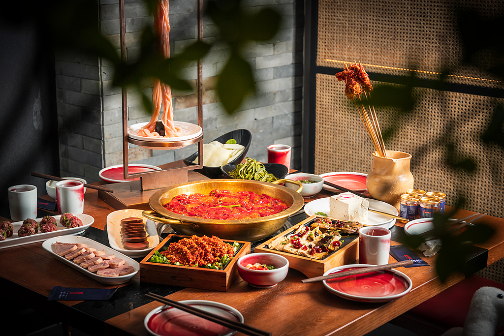 Bubbling broth and colorful side dishes set the stage for a classic Sichuan hot pot meal. /VCG