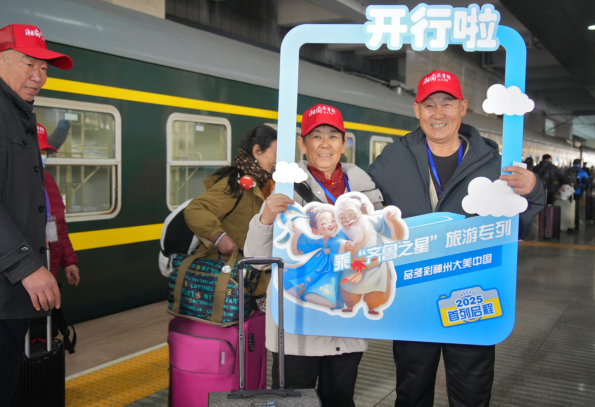 A couple takes a group photo in front of a special tourism train filled with 770 elderly people embarking on its first journey of 2025, Yantai Railway Station in Shandong Province, China, March 9, 2025. /CFP