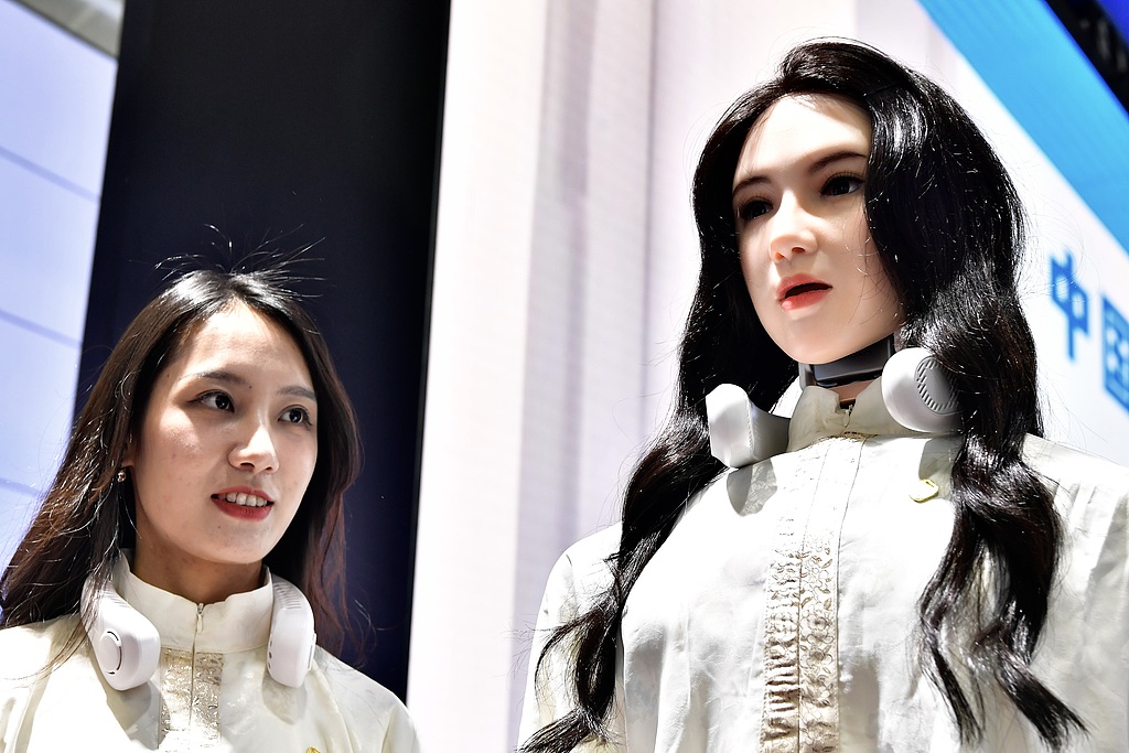 A woman interacts with a robot that mimicked her voice and appearance at the 8th Digital China Summit in Fuzhou, Fujian Province, April, 30, 2025. /VCG
