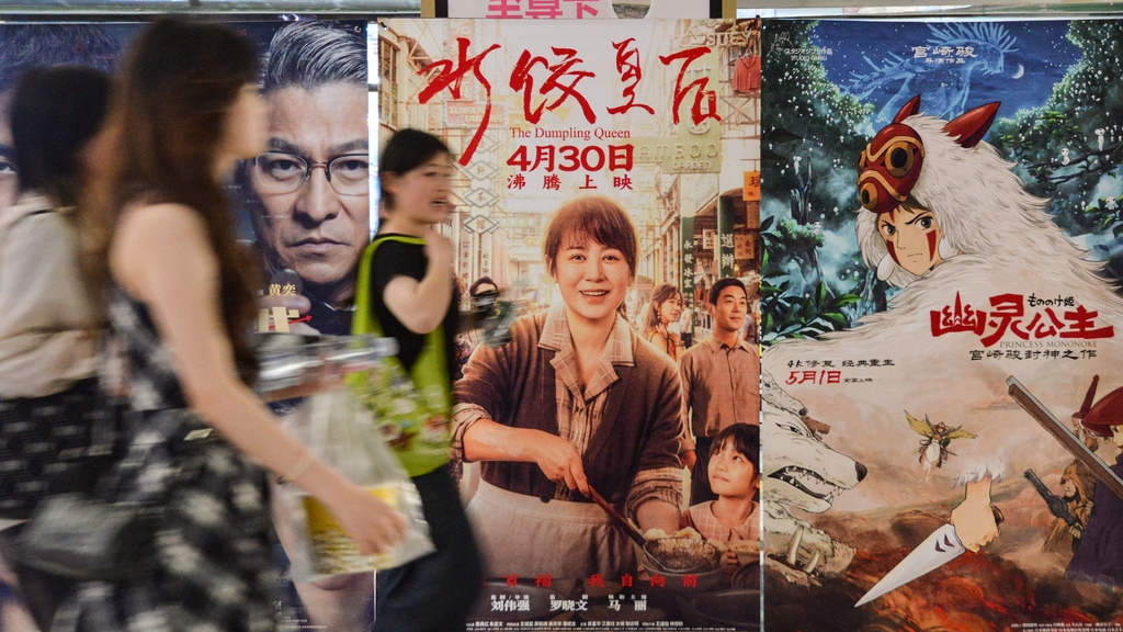 Moviegoers walk past film posters at a cinema in Fuyang, Anhui Province on May 1, 2025. /IC